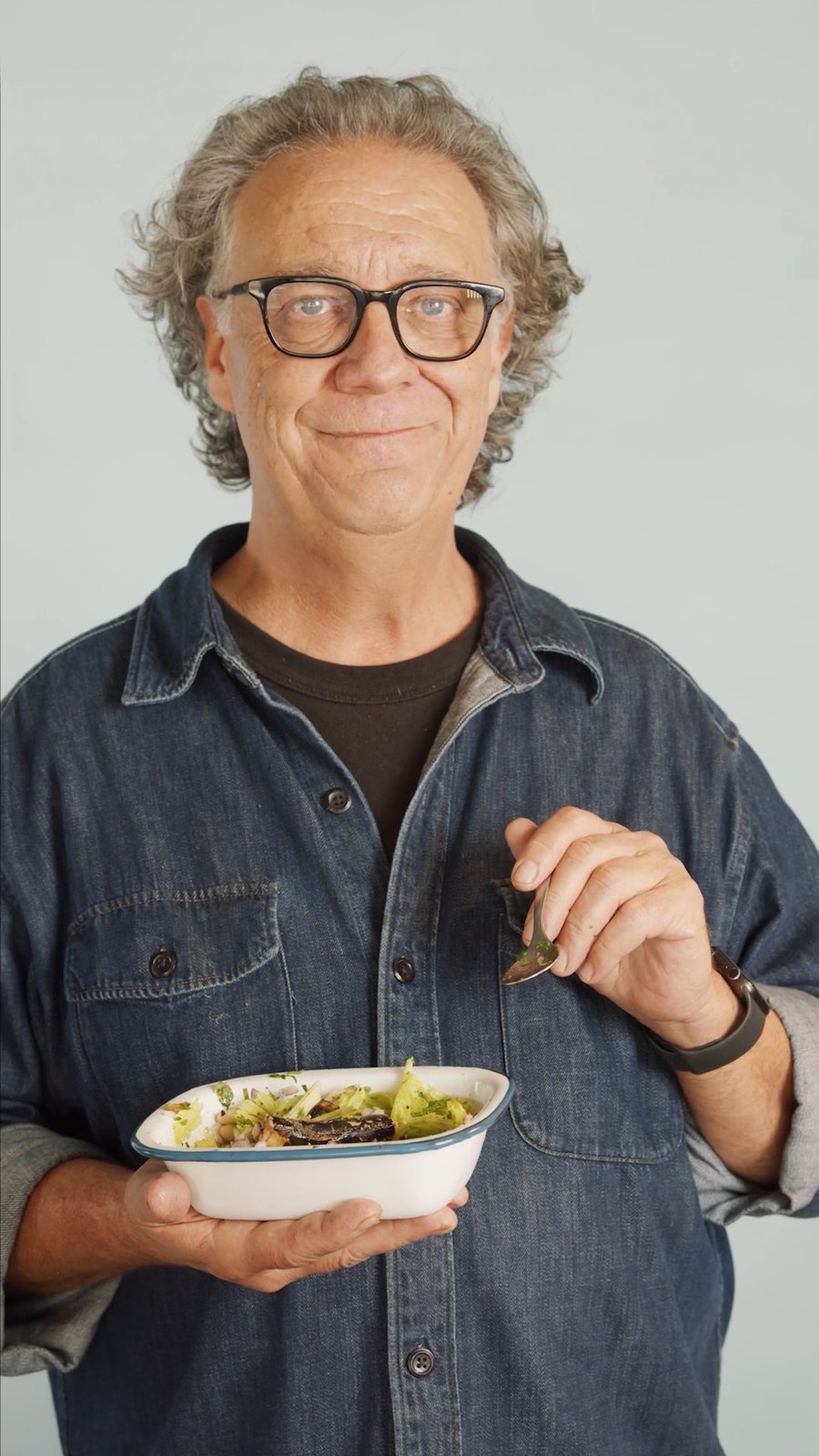 Presenter holding a bowl of salad in the studio